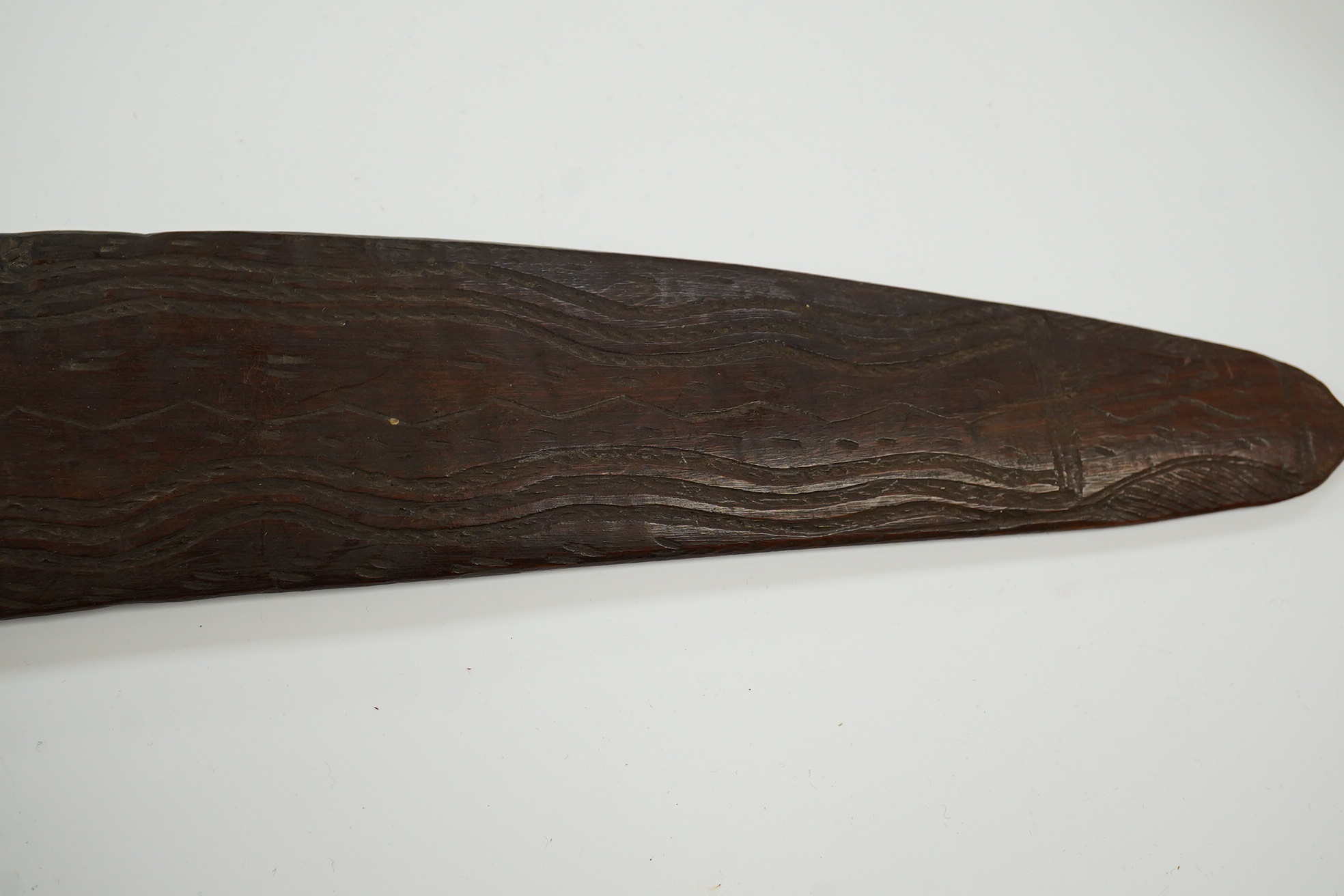 An Aboriginal boomerang, engraved to one side, 76cm wide. Condition - fair to good